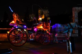 Horse carriages adorned with bright neon lights take families on rides through the city. (Sami Kishawi)